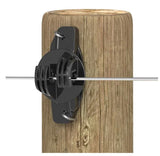 Black electric fence insulator attached to a wooden post with a white background